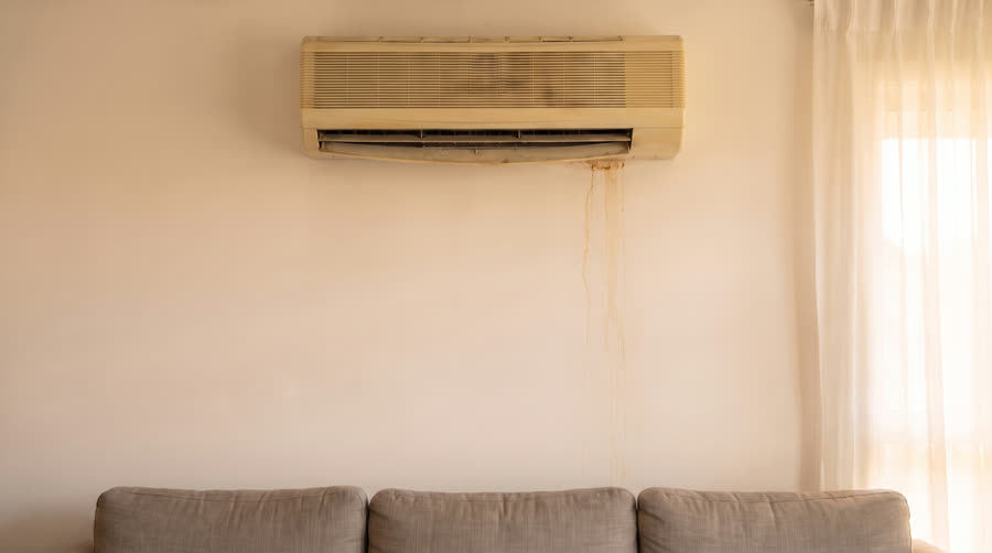 An old air conditioning unit with a water stain before repair