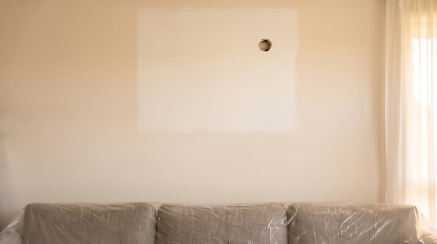 A wall freshly patched and painted after old unit removal